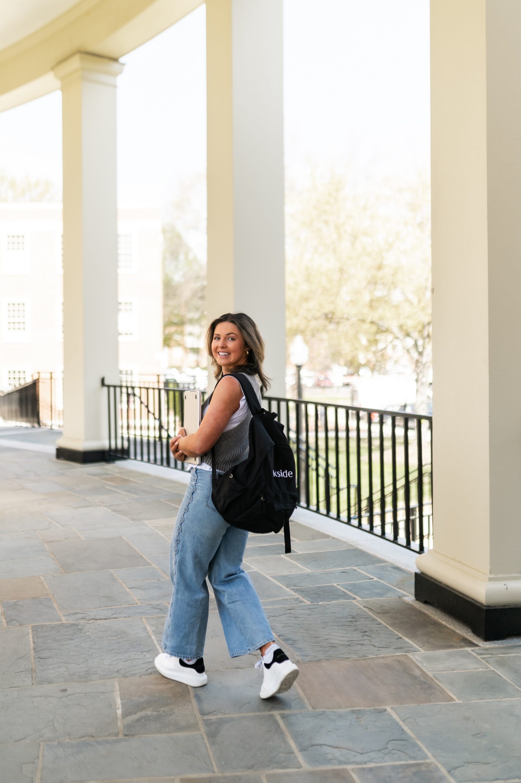 student walking through campus colonnade scaled