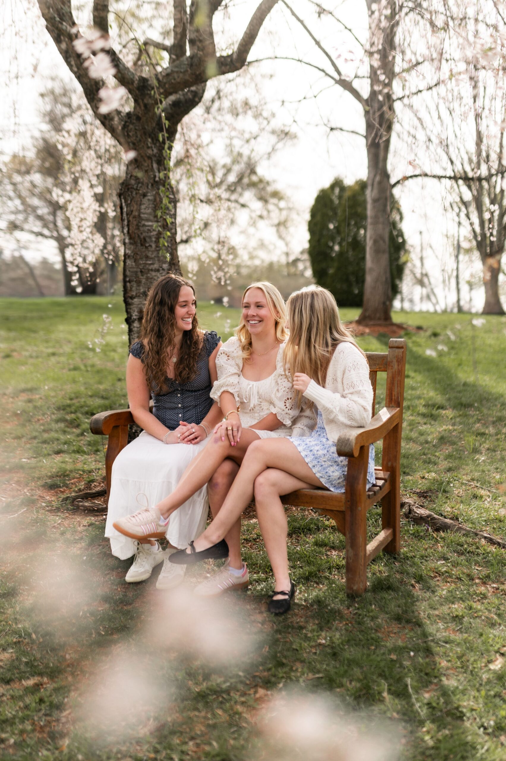 young women sitting on park bench scaled