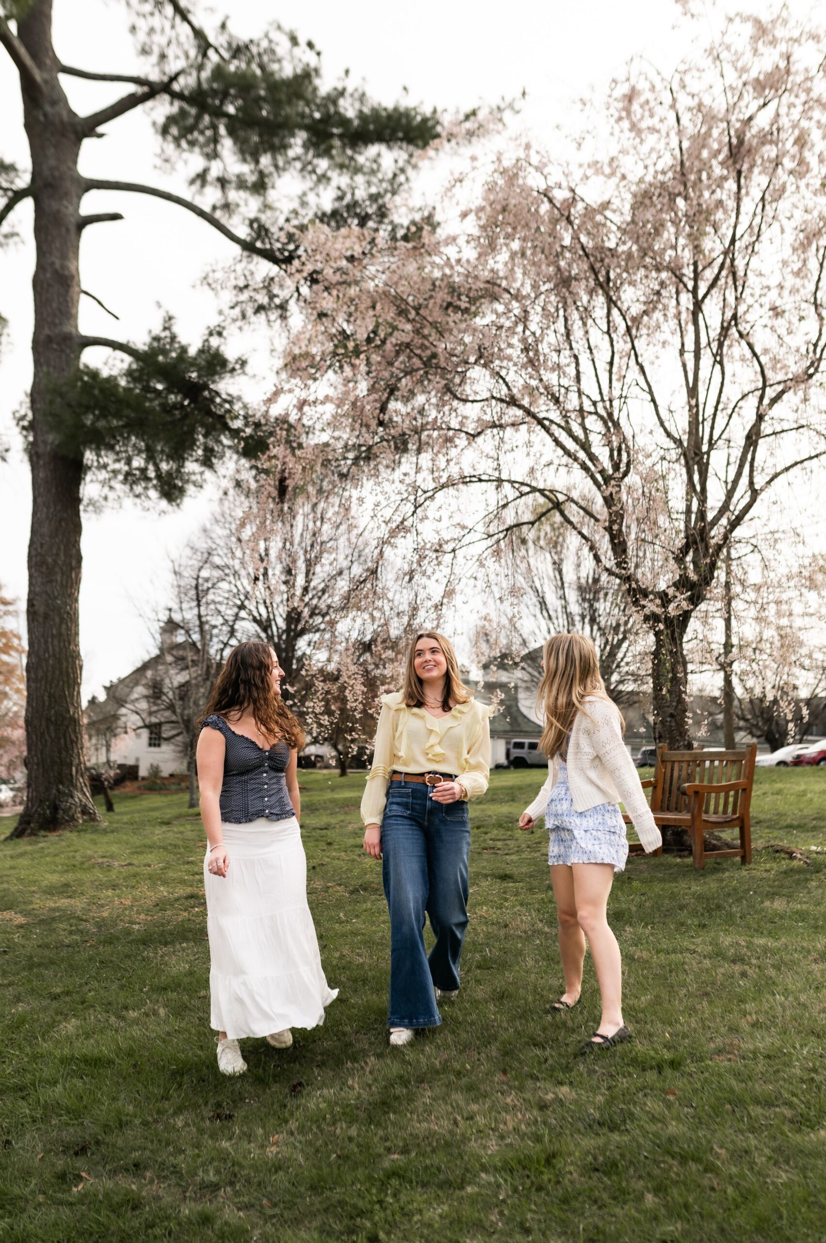 young women strolling across grassy lawn scaled